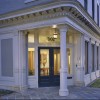 Corner entrance of a warm decorated space of federalist-revival style building at dusk