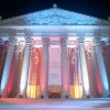 Ornately decorated building with columns. Red, white, and blue colored spot lights are aimed up the columns making a colorful image.