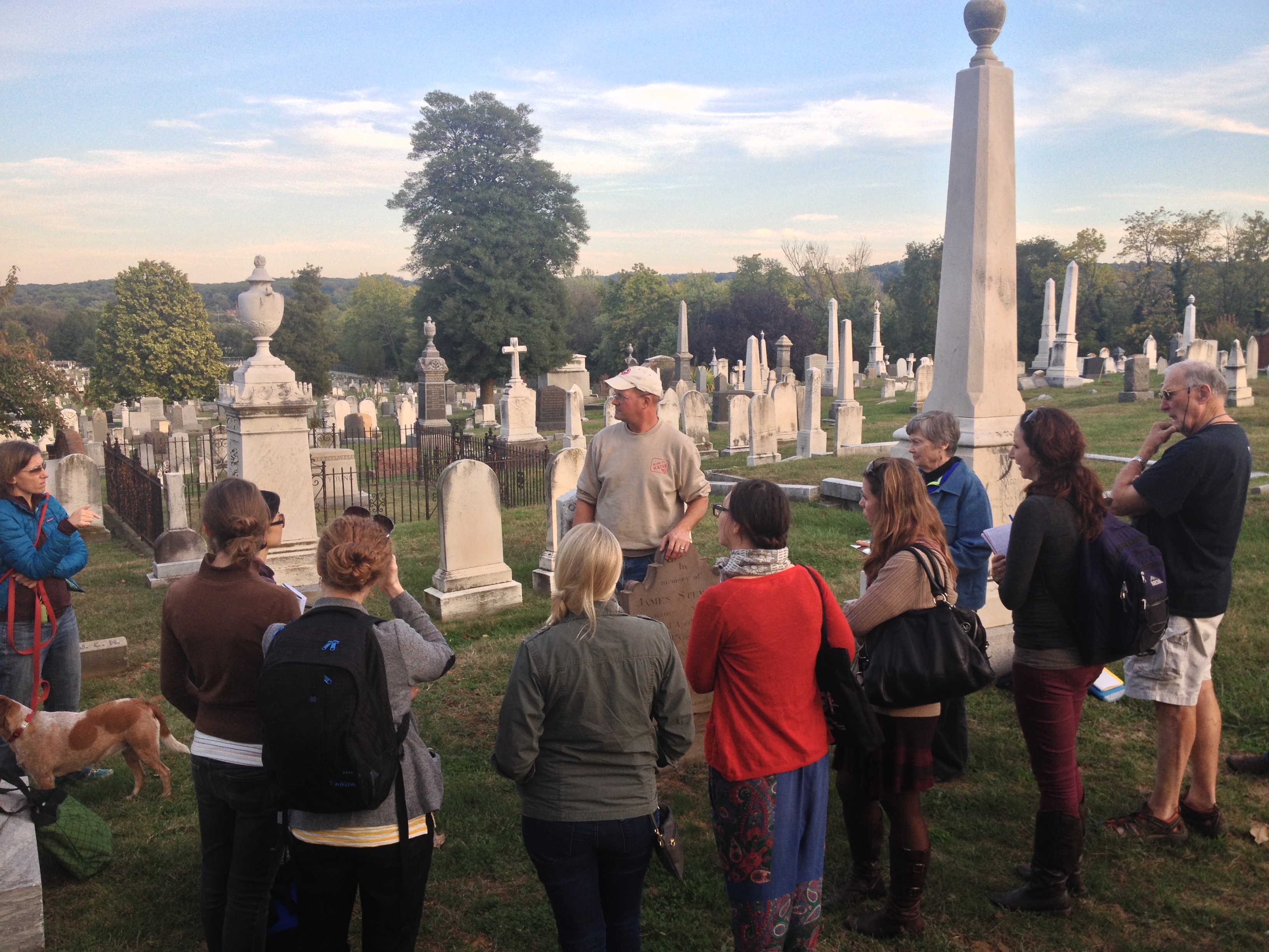 People standing by gravestones with guide