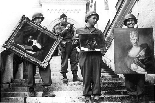 Black and white picture of four soldiers with recovered paintings