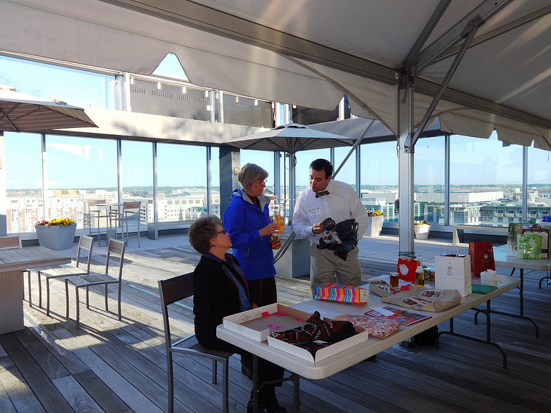 Three people work to give away raffle prizes on a rooftop patio