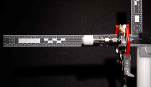 Carbon dioxide cleaning nozzle with stream of CO2 spray shown over a scale