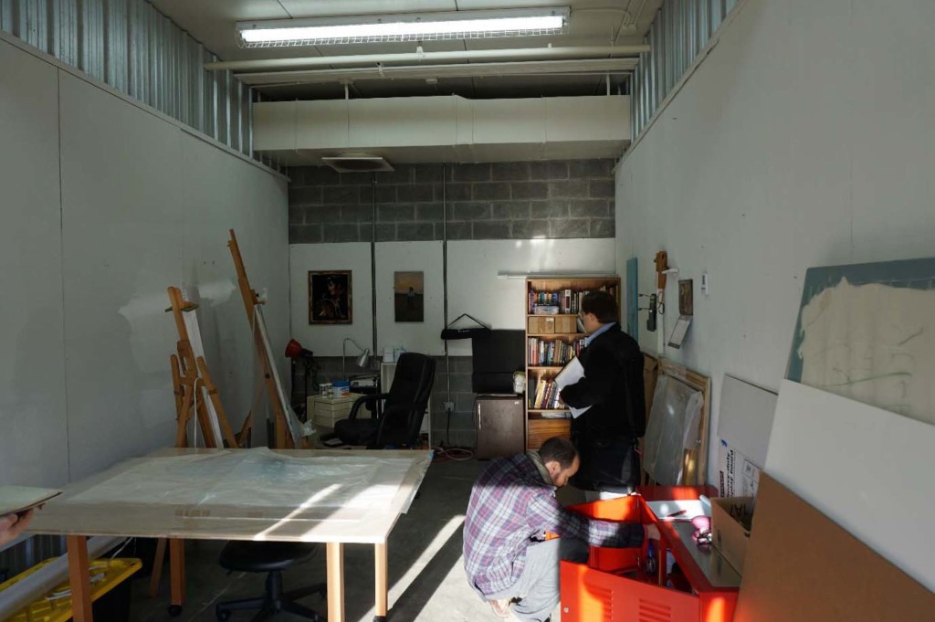 Two people in a cramped workspace with temporary walls