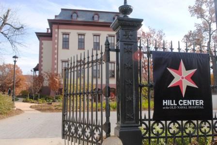 Exterior of the Hill center building and ornate black fence with the center's sign