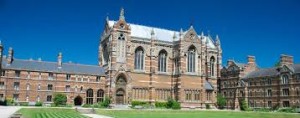 Ornately decorated building with plain brick built wings surrounding a grassy courtyard