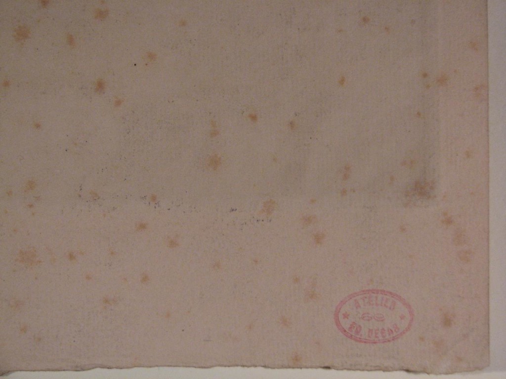 Historic paper with light brown speckles randomly across the surface. Oval red ink stamp in bottom right corner.