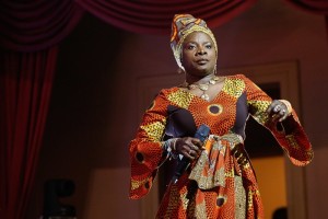 Woman in colorful dress holding microphone on stage