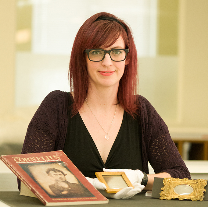 Portrait of the speaker with historic artifacts on a table in front of her