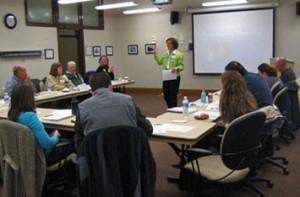 A speaker stands in front of a group of people in a lecture room.