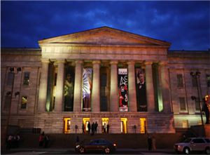 Exterior of gothic revival building with columns and pediment at night