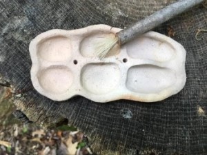 Rustic looking paint palette or ink tray with a handmade brush