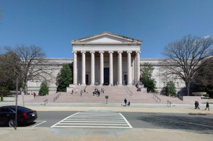 Exterior of the National Gallery of Art. Wide steps leading to a large building with columns. Street in foreground