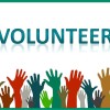 A crowd of raised green, brown, red, and gray hands below large text reading "Volunteer". Green border