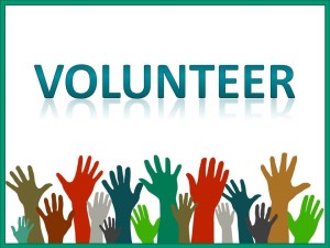 A crowd of raised green, brown, red, and gray hands below large text reading "Volunteer". Green border