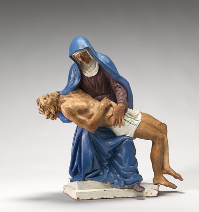 Detailed, painted sculpture of woman in blue robes holding a prone man