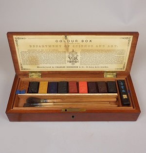 Interior of wooden box with 10 rectangular color blocks and one rectangular india ink block and brushes