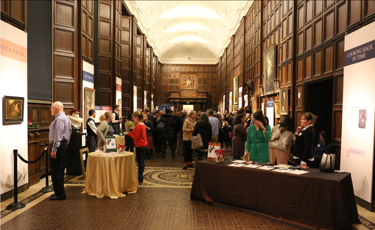 Crowd of people socializing in the Folger Shakespeare Library.