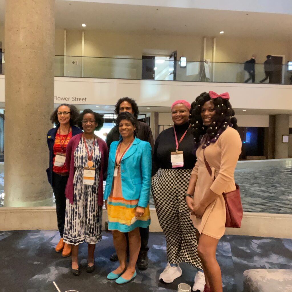 Six members of the Black Art Conservator group pose for a photo in a conference center