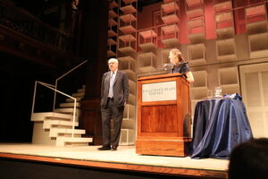 Speaker on stage at the Folger Shakespeare Library with President Diana Gallante