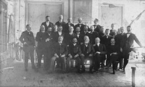 an old black-and-white photography of men in 1890s three-piece suits.