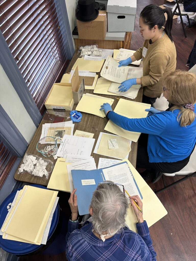 3 people rehousing documents in folders