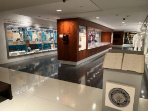 View of museum gallery with cases of objects.