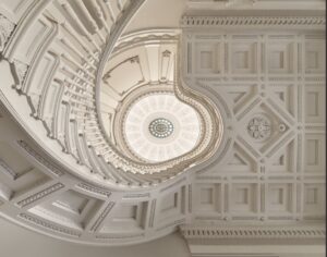 View looking up at staircase and ceiling with decorative moulding